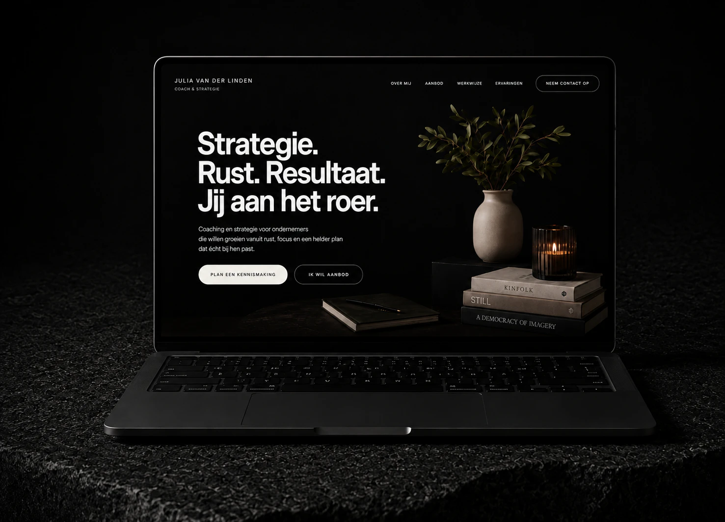 Donkere laptop waarop een stijlvolle coachwebsite met een plant, boeken en kaars wordt getoond